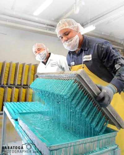 Two workers holding tray of dipped candy at manufacturing plant in Canajoharie New York