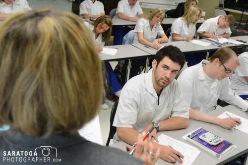 Class of medical students listening to instructor in classroom