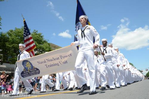 Low angle view of Navy sailors in dress whites marching in the parade with blue sky above