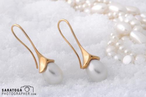 Pearl pendant gold loop earrings with pearl necklace on white snow background